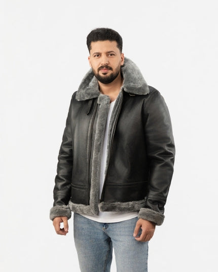 Man wearing a dark leather jacket with gray shearling collar and cuffs on a white background