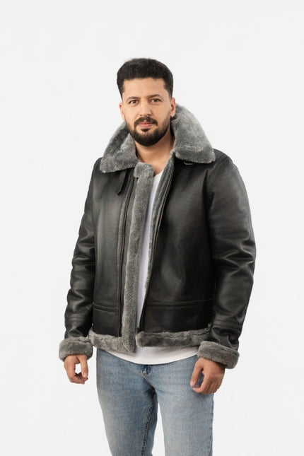 Man wearing a dark leather jacket with gray shearling collar and cuffs on a white background