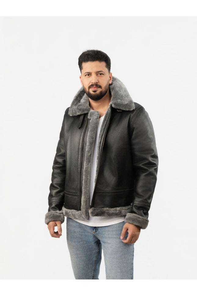 Man wearing a dark leather jacket with gray shearling collar and cuffs on a white background