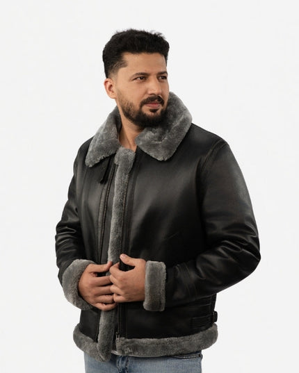 Man wearing a black leather jacket with gray fur lining on a white background
