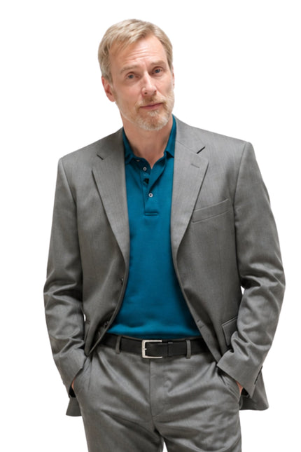 Man wearing a gray suit and blue shirt on a white background