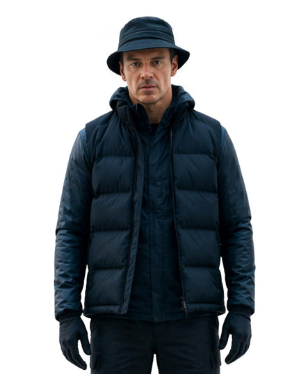Man wearing a dark blue puffer jacket, hat, and gloves on a white background