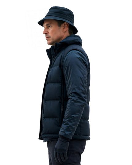 Man wearing a dark blue puffer jacket and hat on a white background