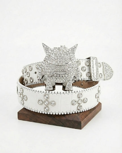 Silver belt buckle with crystals on a white belt, displayed on a wooden stand against a white background.