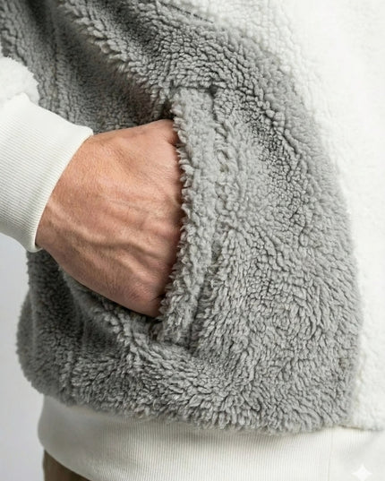 Close-up of a person wearing a gray fleece jacket with a white shirt underneath.