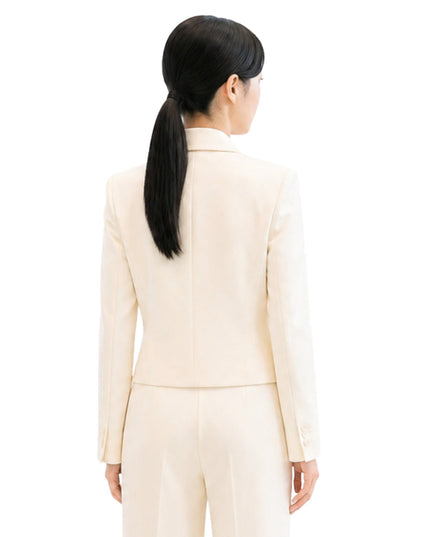 Woman wearing a beige suit on a white background