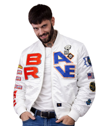 Man wearing a white bomber jacket with colorful text and patches on a white background