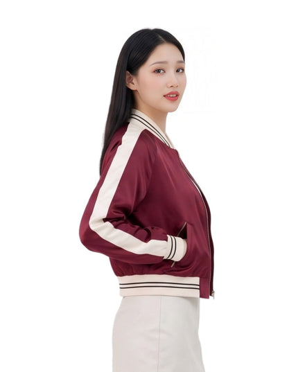 Woman wearing a maroon jacket with white accents on a white background