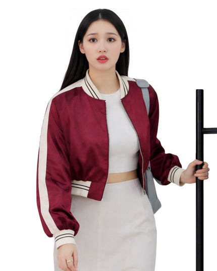 Woman wearing a red and white jacket holding a black object on a white background