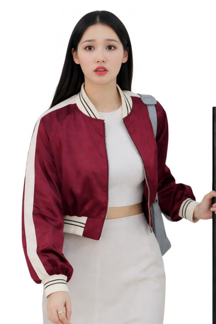 Woman wearing a red and white jacket holding a black object on a white background