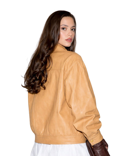 Woman wearing a tan leather jacket on a white background