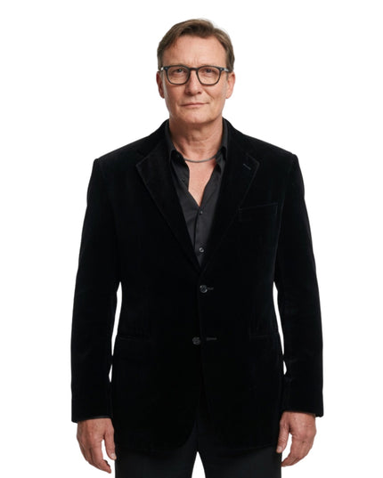 Man wearing a black velvet blazer on a white background