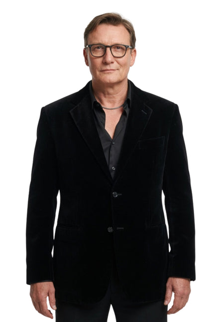 Man wearing a black velvet blazer on a white background