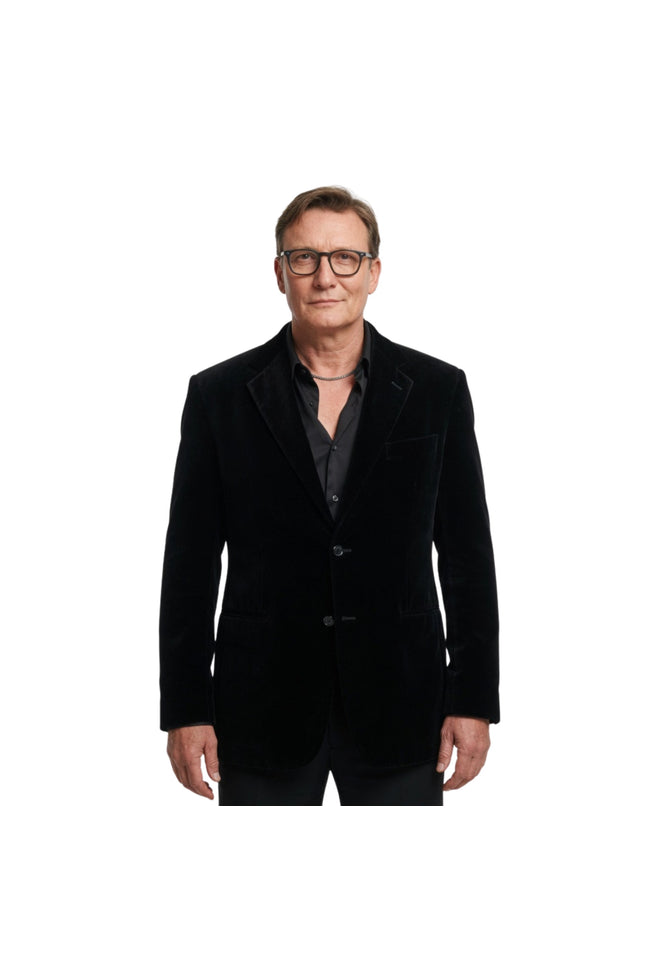 Man wearing a black velvet blazer on a white background