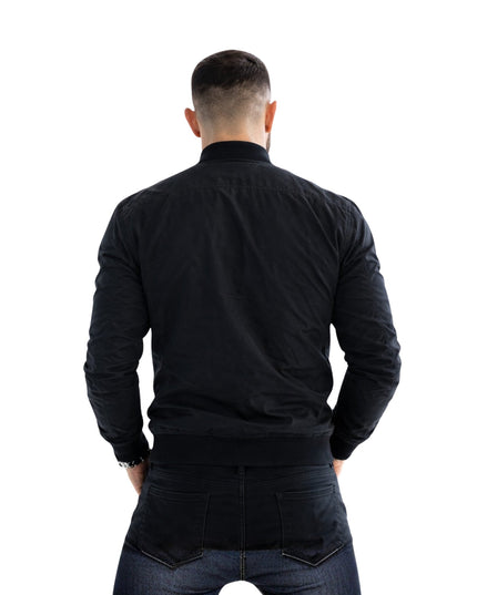 Man wearing a black jacket and jeans from behind on a white background