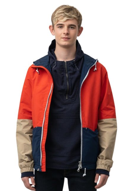 Person wearing a colorful jacket with red, blue, and beige sections on a white background