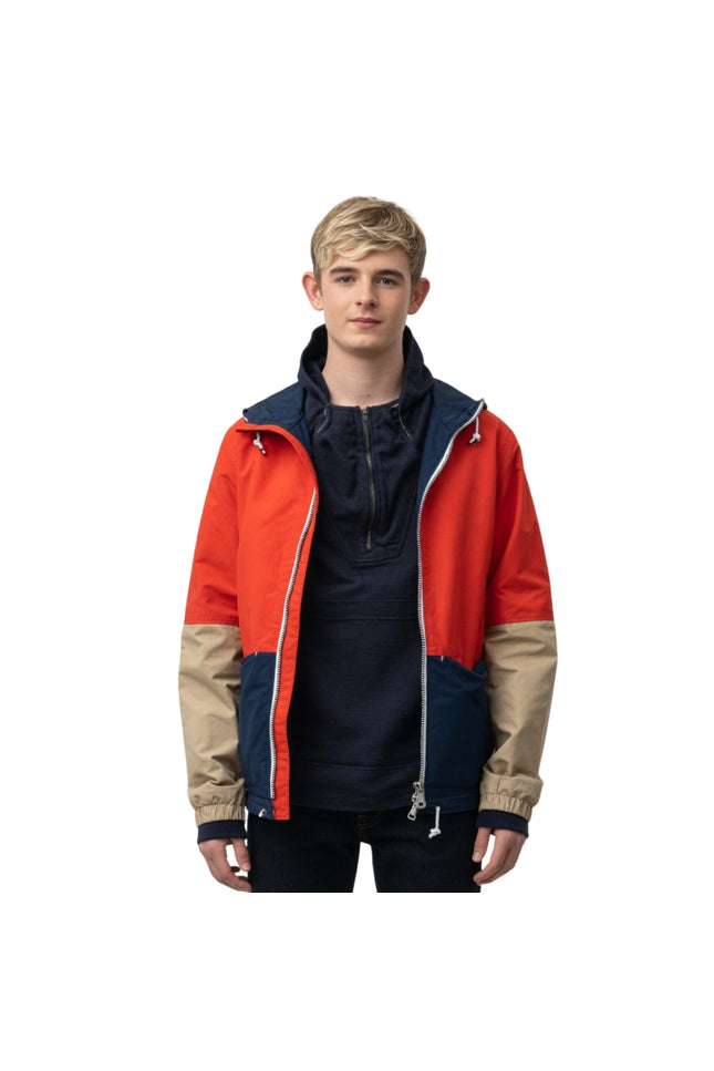 Person wearing a colorful jacket with red, blue, and beige sections on a white background