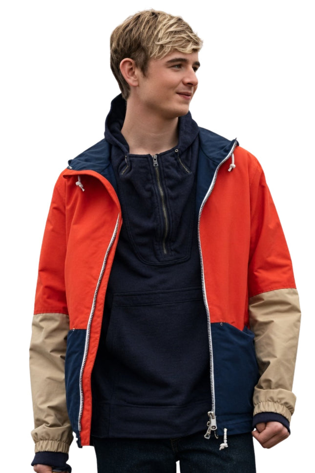 Person wearing a colorful jacket with red, blue, and beige sections on a white background