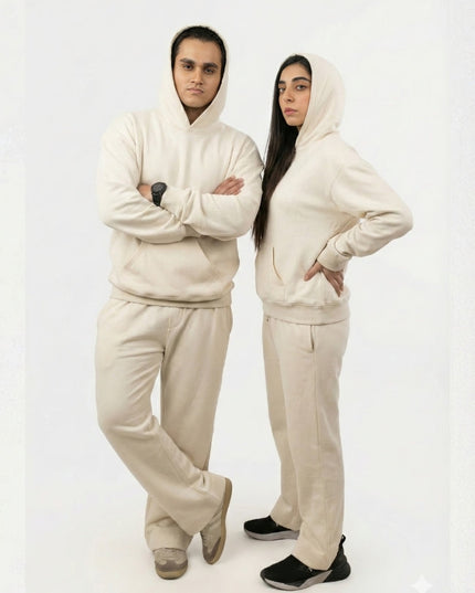 Two people wearing matching beige outfits on a white background