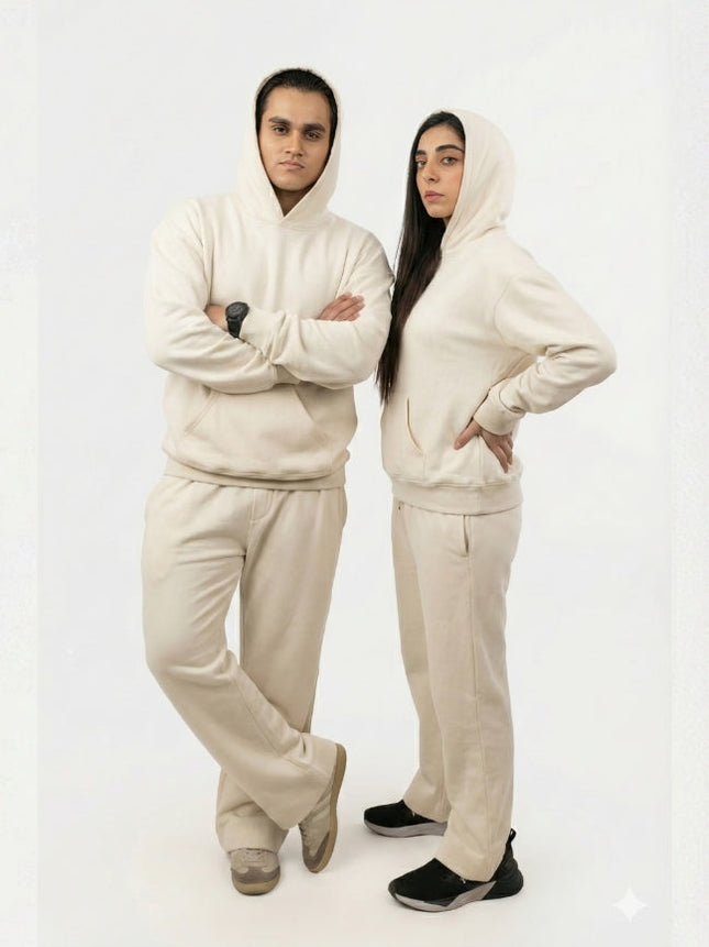 Two people wearing matching beige outfits on a white background