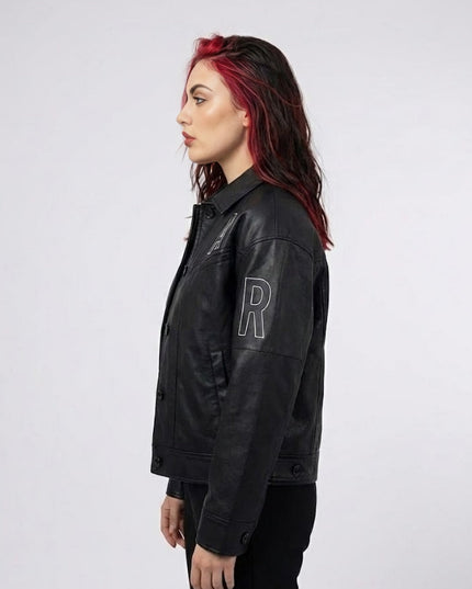 Person wearing a black jacket with a large letter 'R' on a white background
