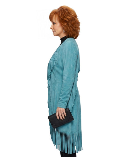 Woman wearing a teal fringe dress holding a black clutch on a white background