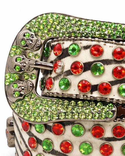 Decorative belt buckle with green and red gemstones on a white background
