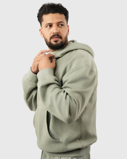 Man wearing a light green hoodie on a white background