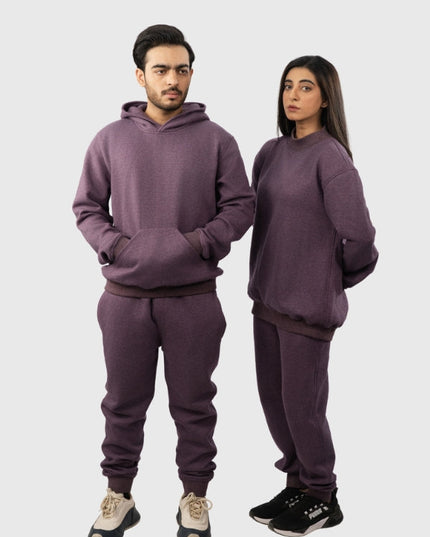 Two people wearing matching purple sweatsuits on a white background