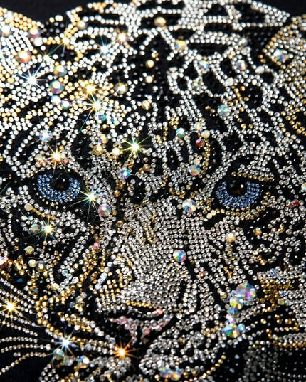 Leopard face design made with rhinestones on a black background