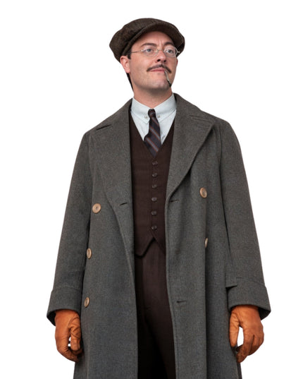 Man wearing a vintage outfit with a long coat, vest, tie, and gloves on a white background