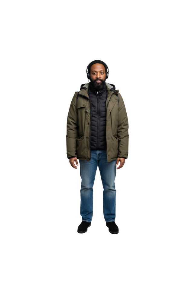 Man wearing a green winter coat, black shirt, blue jeans, and headphones on a white background