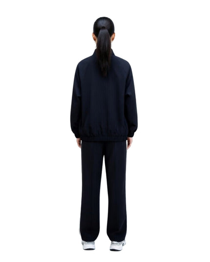 Person wearing a black tracksuit on a white background