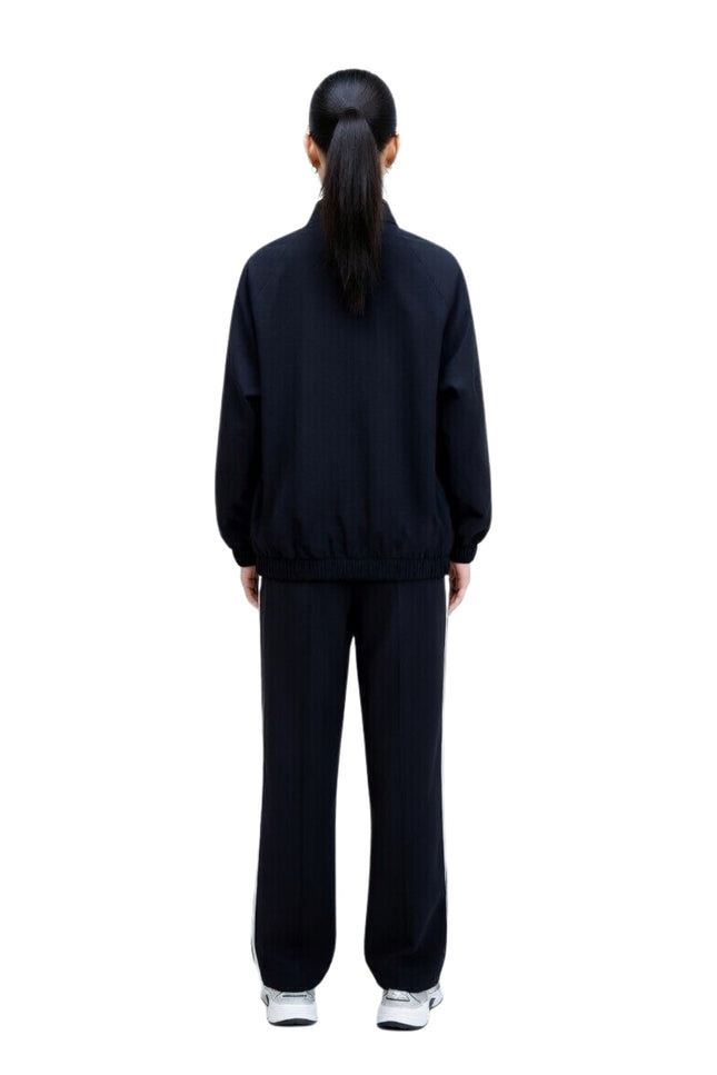 Person wearing a black tracksuit on a white background