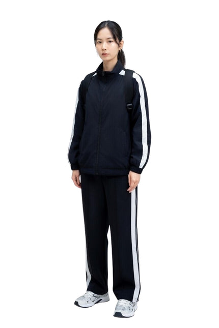 Person wearing a black tracksuit with white stripes on a white background
