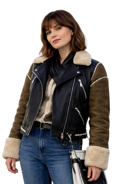 Woman wearing a black and brown leather jacket with fur trim on a white background