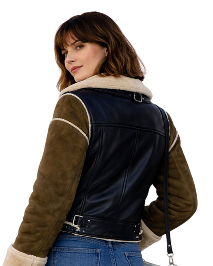 Woman wearing a black and brown leather jacket with shearling trim on a white background