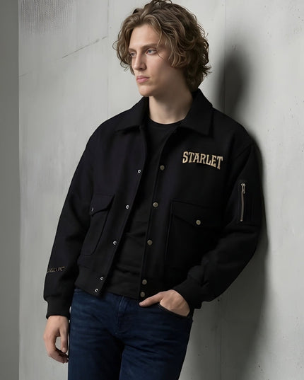 Person wearing a black jacket with 'STARLET' branding against a gray wall