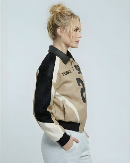 Woman wearing a black, beige, and white jacket on a light gray background