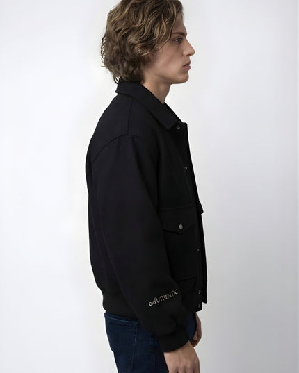 Person wearing a black jacket with 'Authentic' branding on a white background