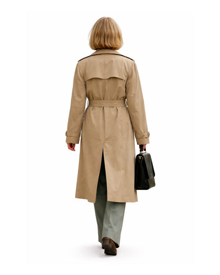 Person wearing a beige trench coat on a white background