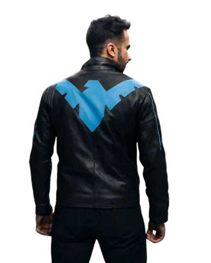 Person wearing a black leather jacket with a blue logo on the back against a white background