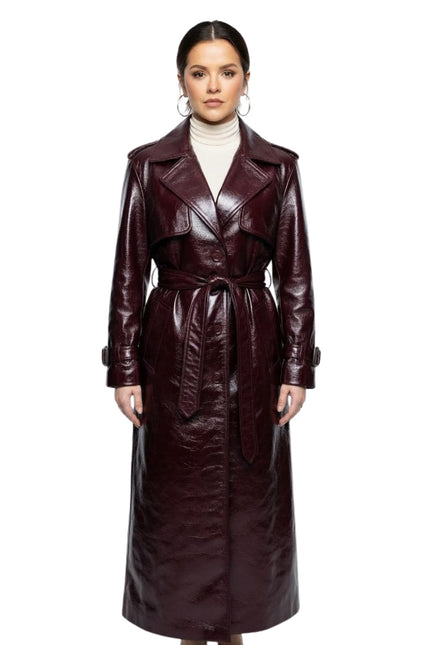 Woman wearing a long brown leather coat on a white background