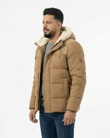Man wearing a brown puffer jacket with a white hood on a light gray background