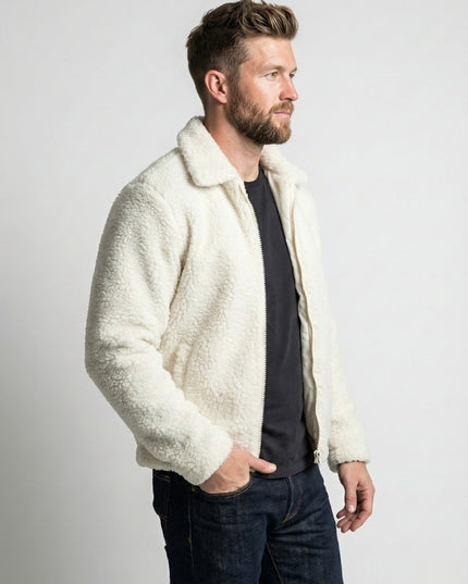 Man wearing a cream sherpa jacket against a plain background
