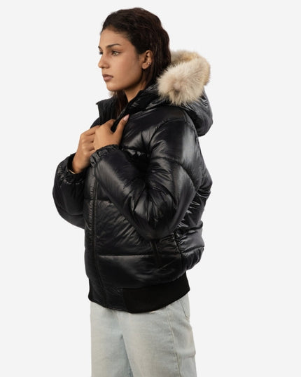 Woman wearing a black puffer jacket with fur hood on a white background