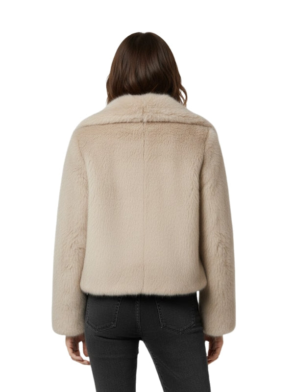 Beige shearling jacket worn by a person on a white background