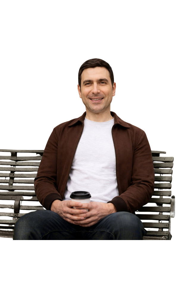 Man sitting on a bench holding a coffee cup against a white background
