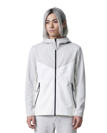 Person wearing a white jacket with black zippers on a white background