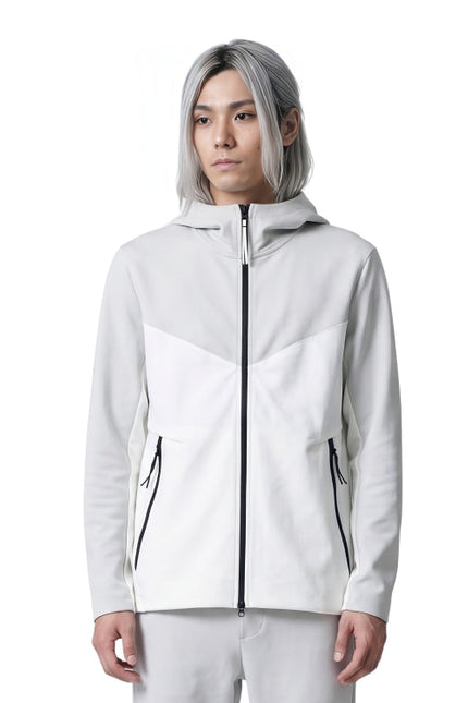 Person wearing a white jacket with black zippers on a white background
